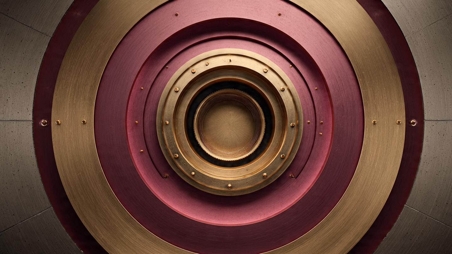 A precision bank-vault door — maroon and gold concentric rings — illustrating financial-grade security.